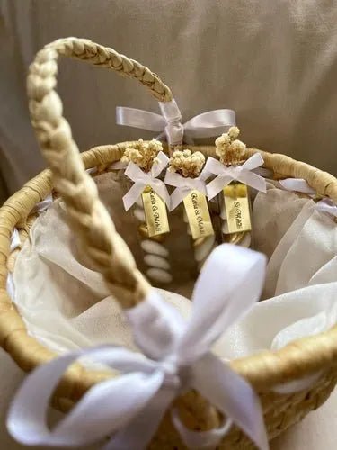 Dragées Valencia personnalisées pour le mariage de Katia et Mehdi présentées dans un panier en osier avec rubans blancs