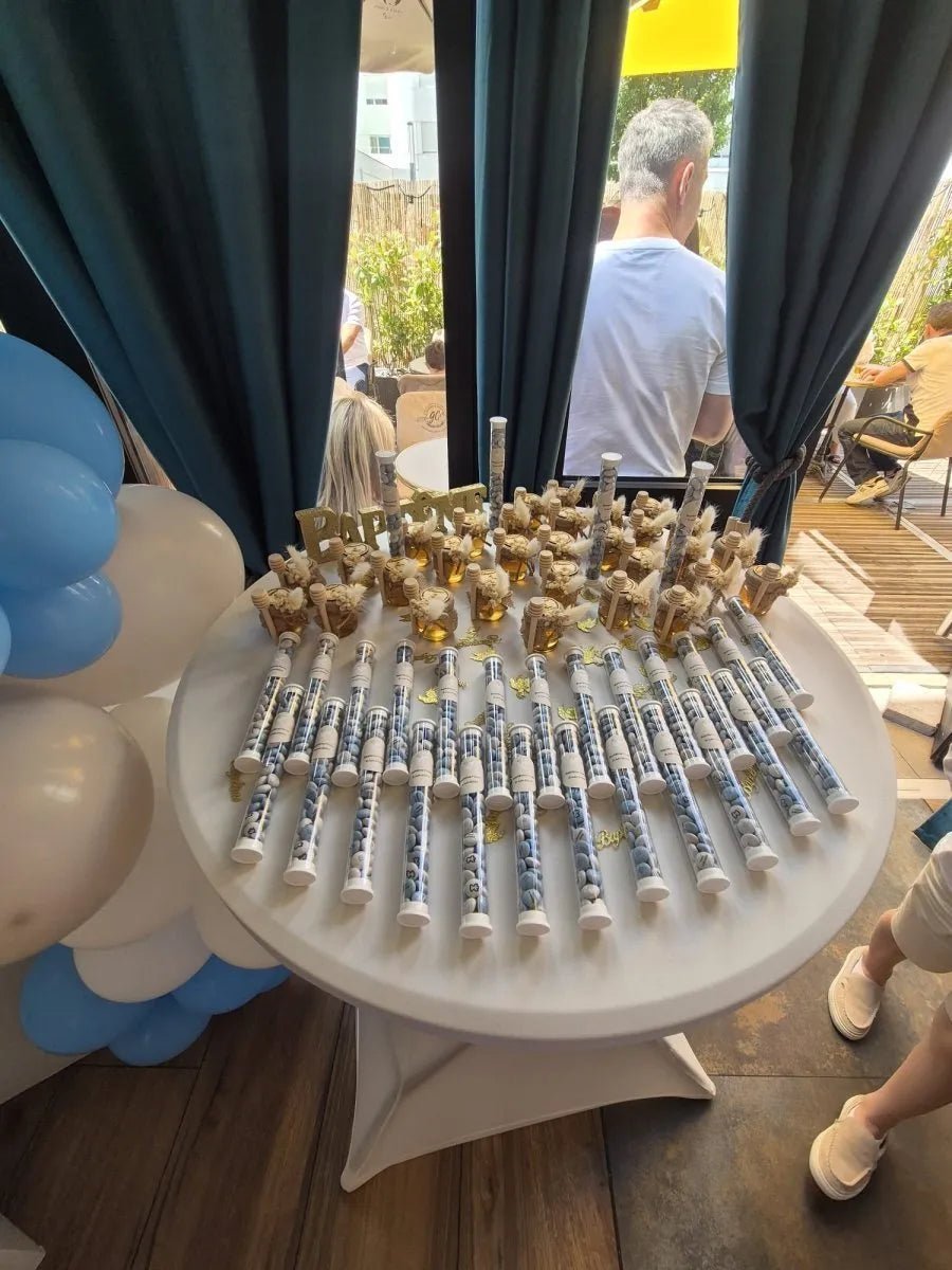 Pots de Miel Pampa personnalisés et tubes de dragées sur une table champêtre pour le baptême de Flavio du 9 juin 2024