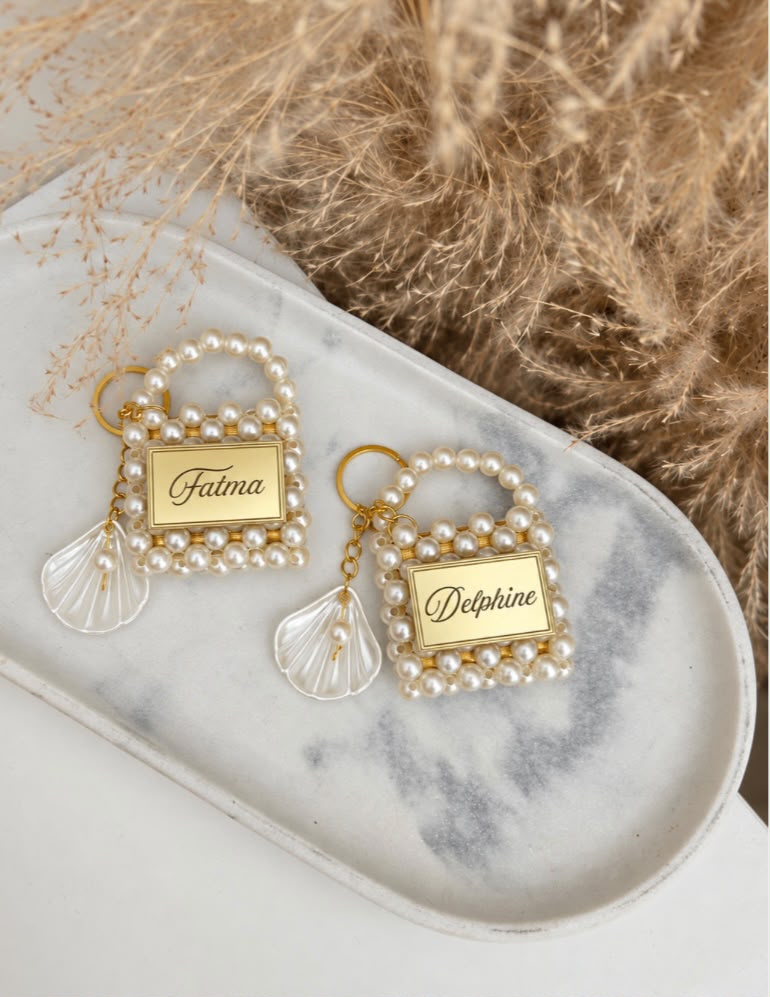 Sacs Nacre Bella alignés sur fond marbré, cadeaux invités personnalisés mariage