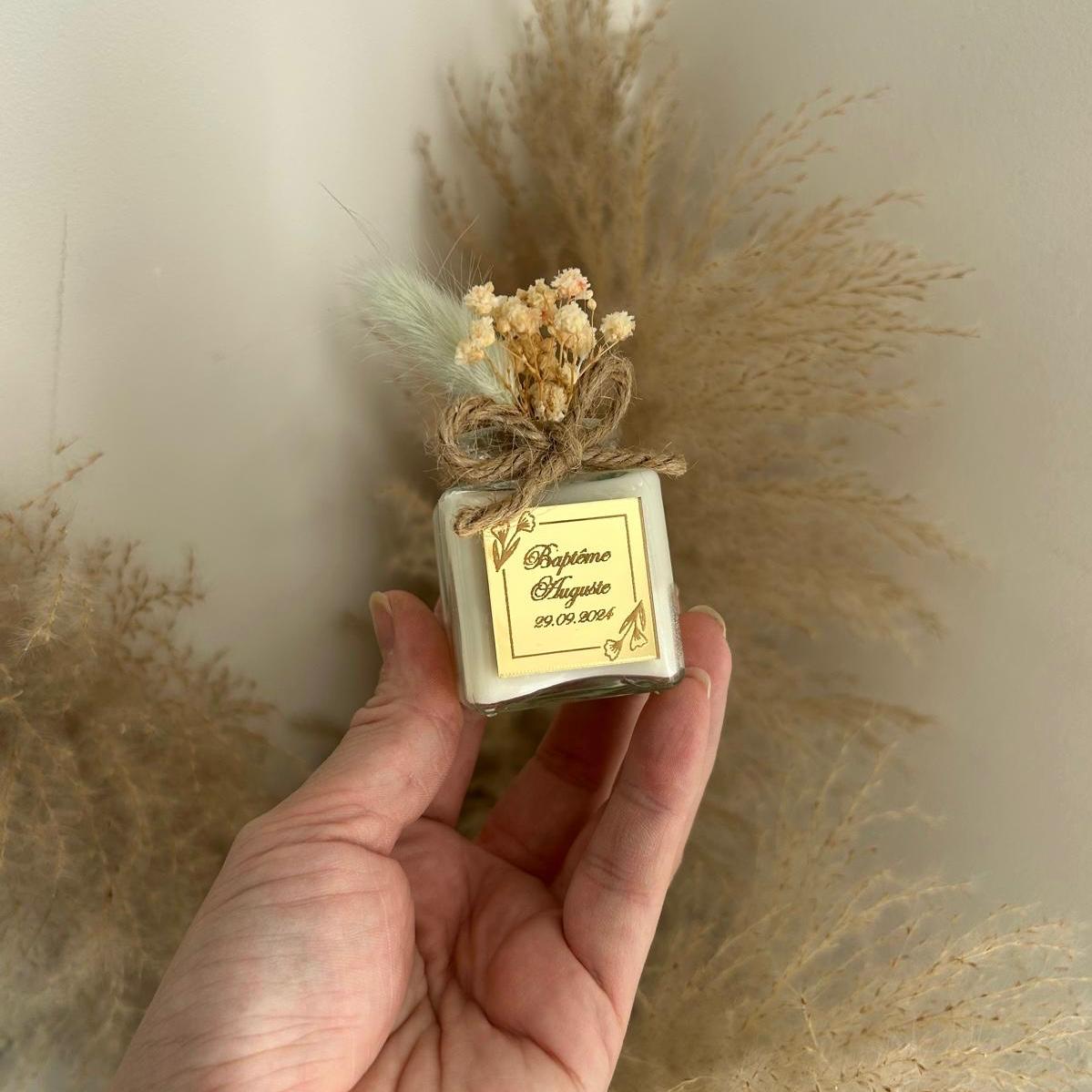 Cadeau invité baptême : bougie blanche style bohème avec jute et fleurs séchées, personnalisée avec prénom et date.