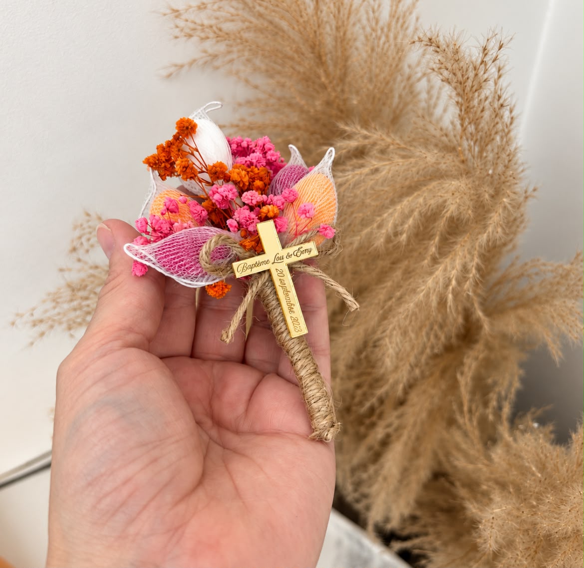 Bouquet Croix Fiorella tenu en main, cadeau invité baptême fleurs séchées