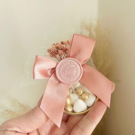 Cadeau invité : sachet de dragées Russia en tulle avec ruban satin rose, sceau décoratif et fleurs séchées.