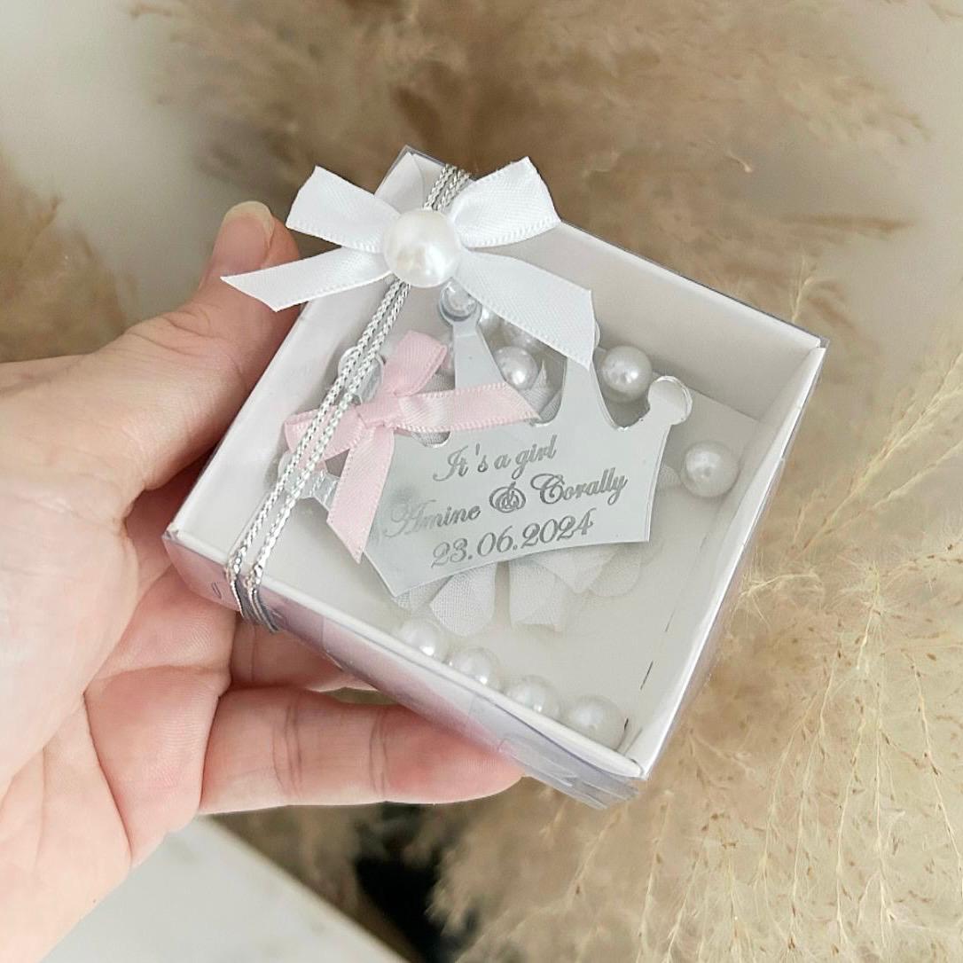 Cadeau invité naissance : boîte transparente décorée de perles blanches, nœud satin blanc et rose, couronne gravée en plexiglas